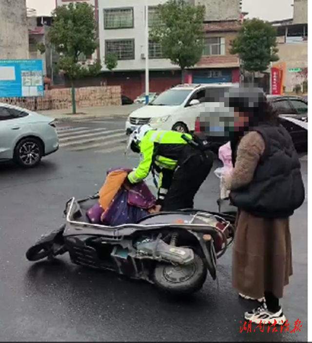 道縣：女士雨天騎車摔倒 執(zhí)勤交警暖心扶起