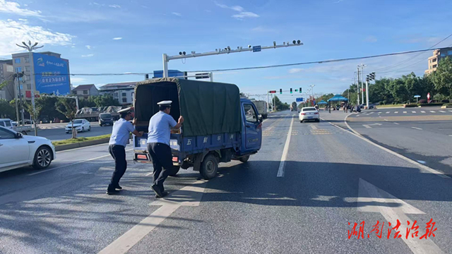 道县：三轮车故障趴窝 交警帮助推车解困