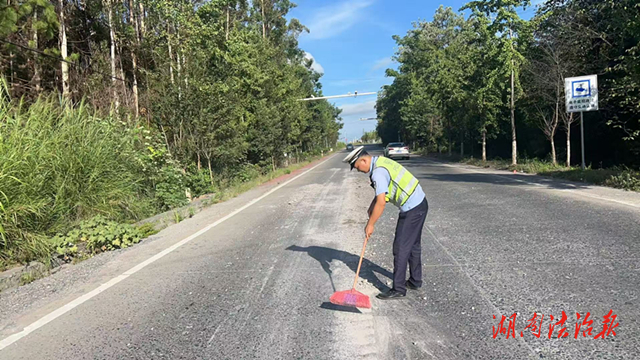 道县：路面散落砂石 交警化身“清洁工”
