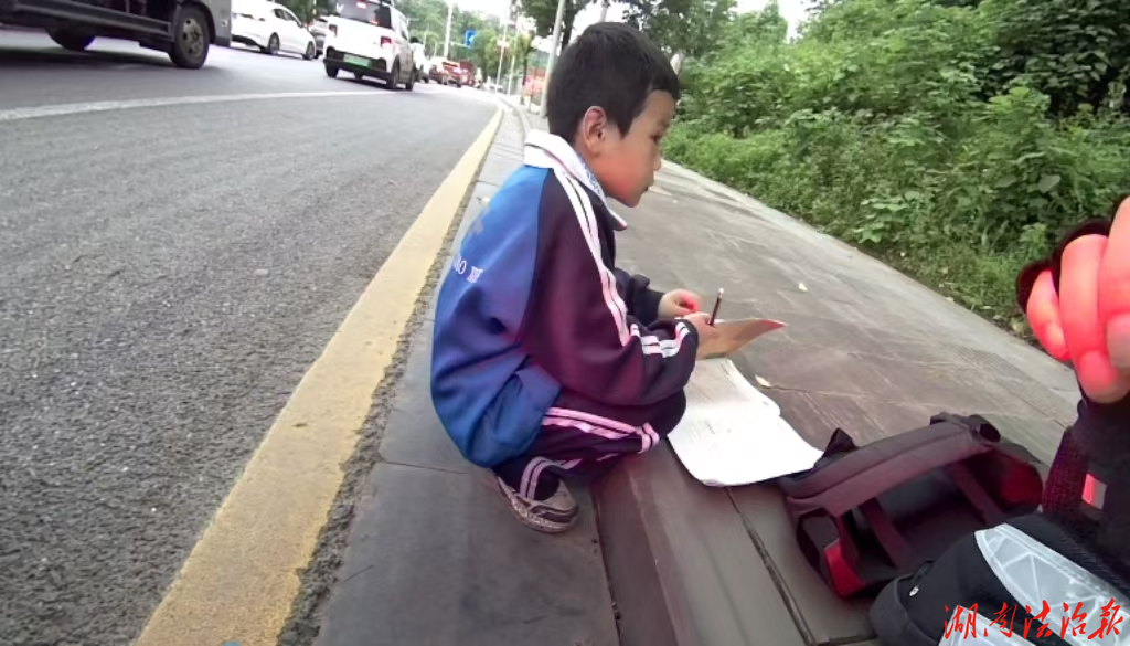 小學生在路邊寫作業(yè) 民警暖心勸導護平安